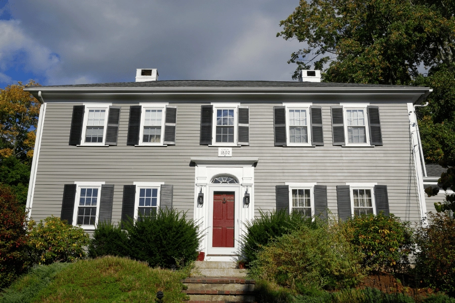 Georgian home with black shutters and bright red front door